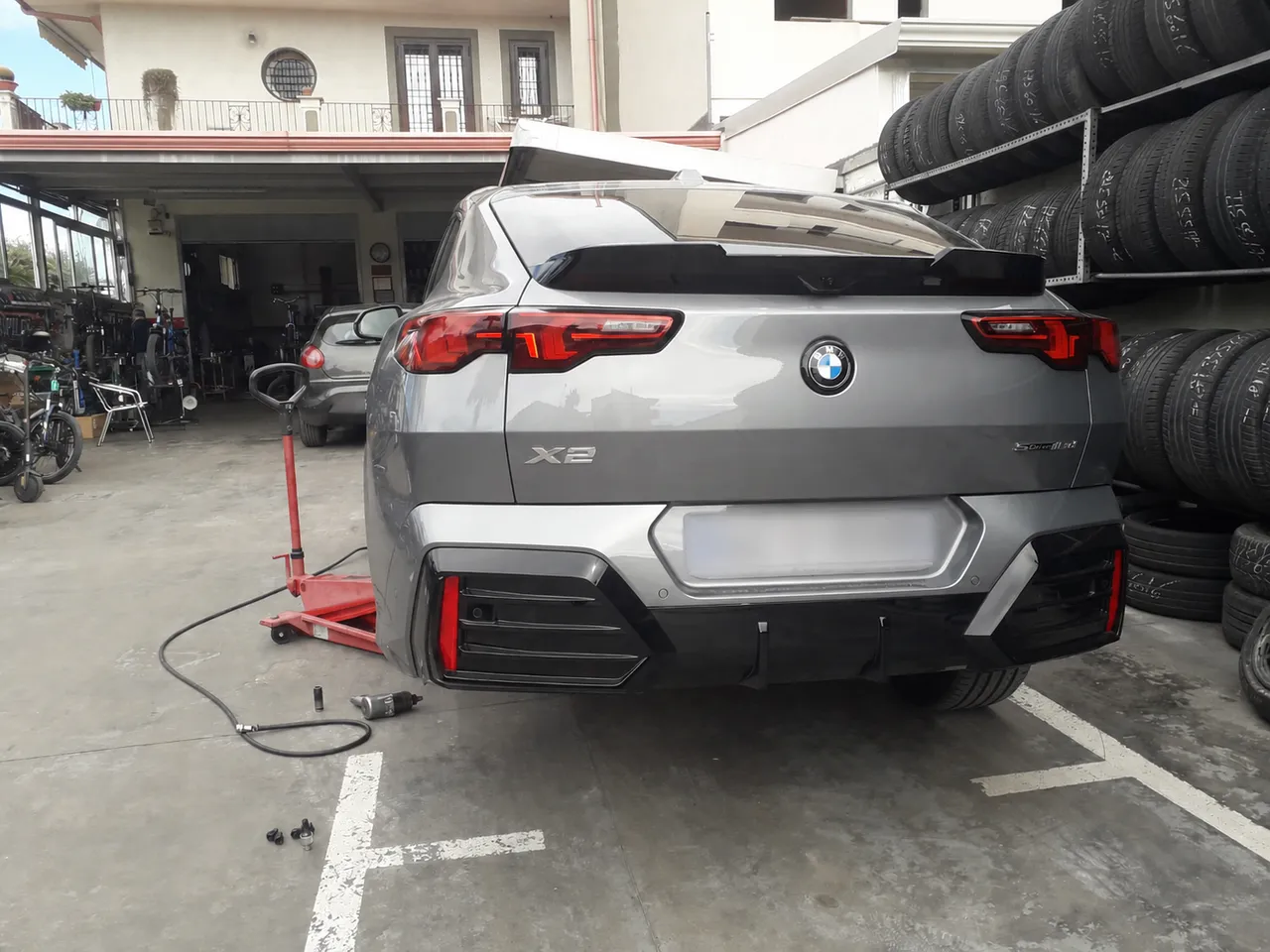 BMW X2 in lavorazione: ruota smontata, attrezzi pronti e nessuna fretta.