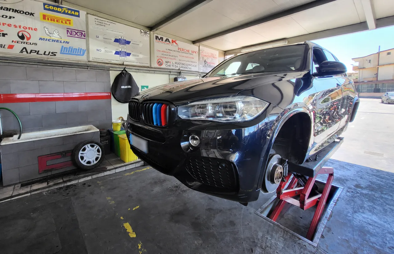 SUV sul ponte a scomparsa con le ruote smontate: il cambio gomme comincia da qui.