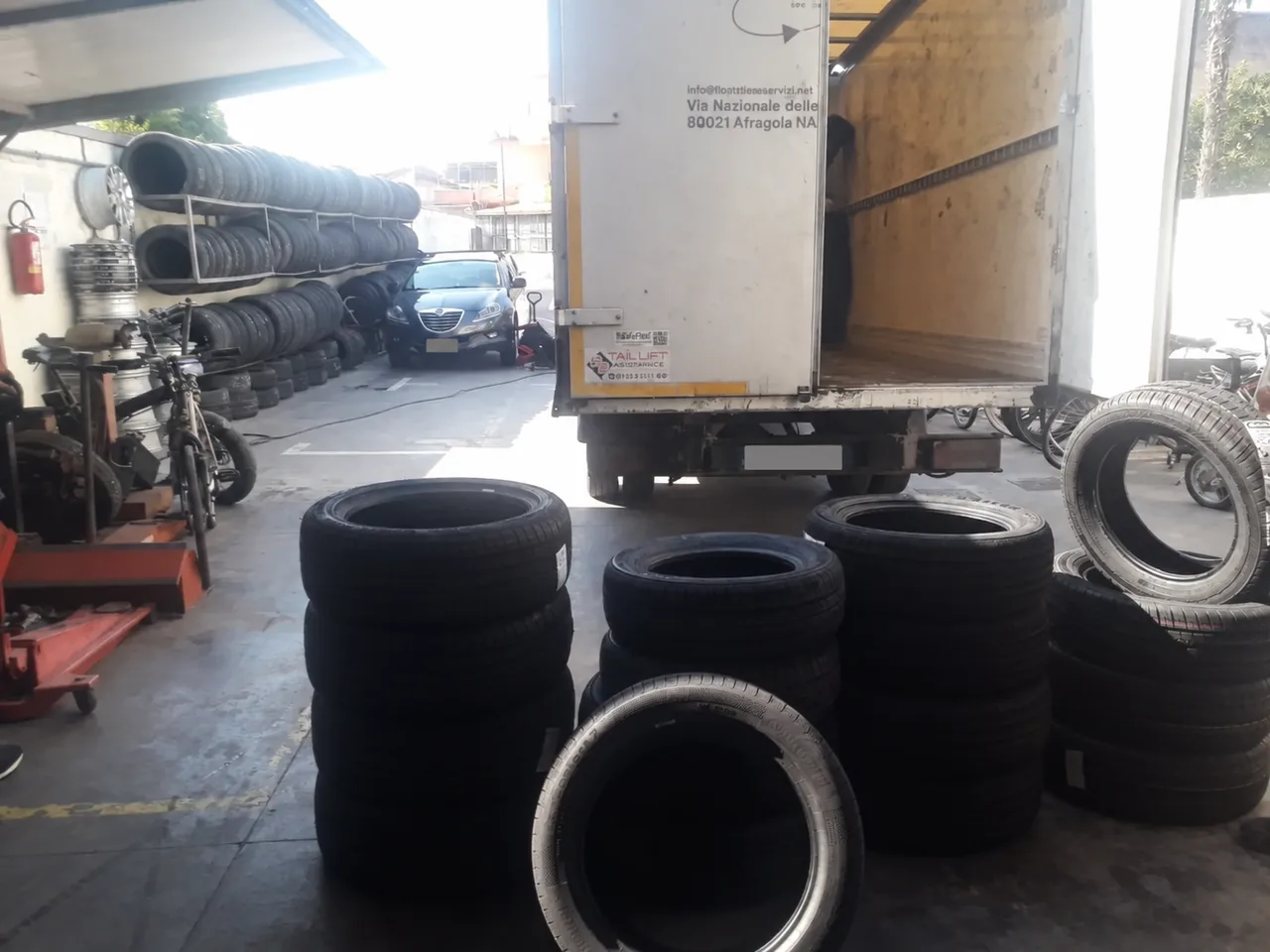 Fornitura di pneumatici in arrivo: le gomme vengono ricevute e organizzate in officina.