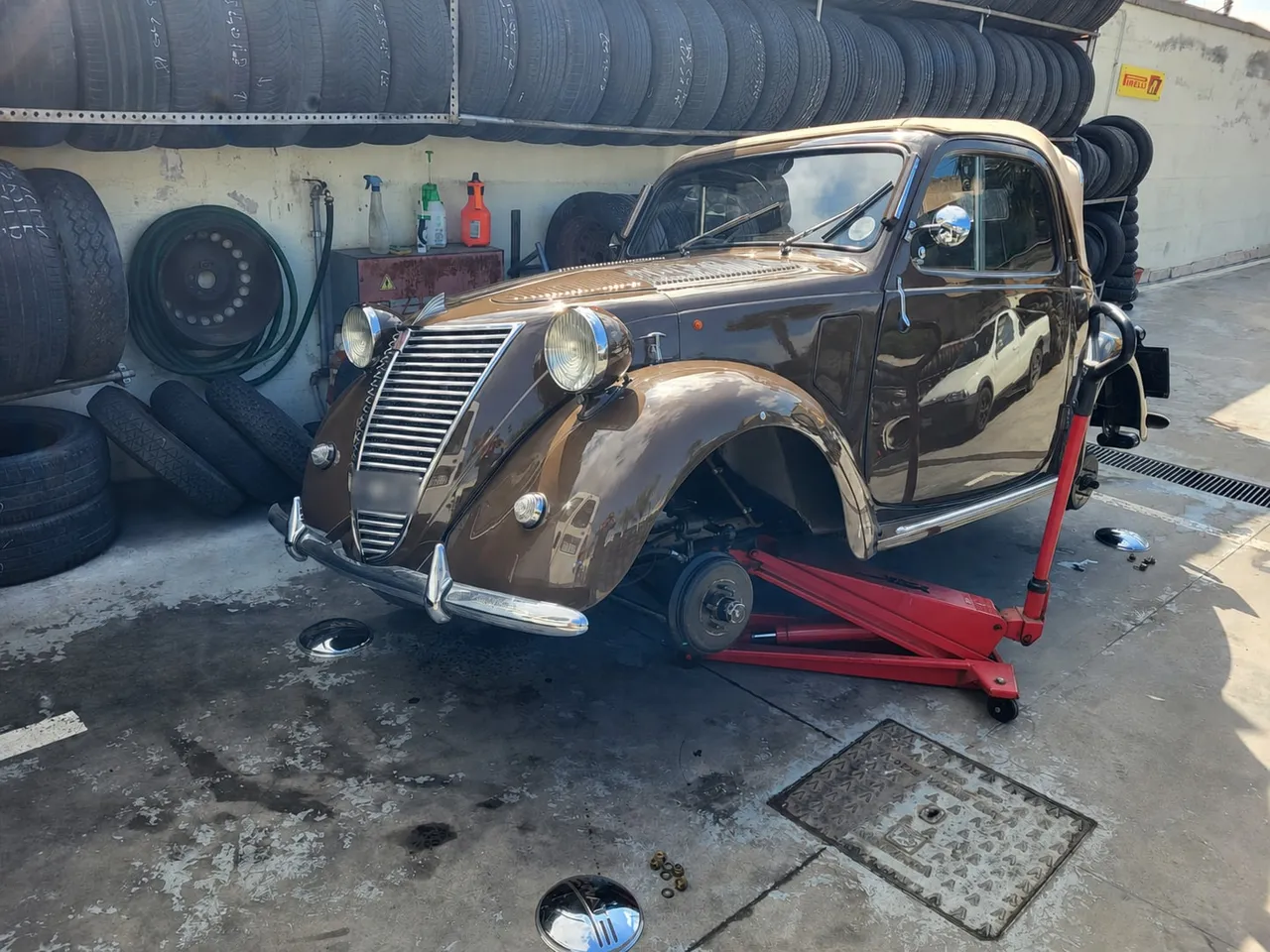 Auto d'epoca sollevata con cura: prima si mette in sicurezza, poi si interviene su ruote e gomme.